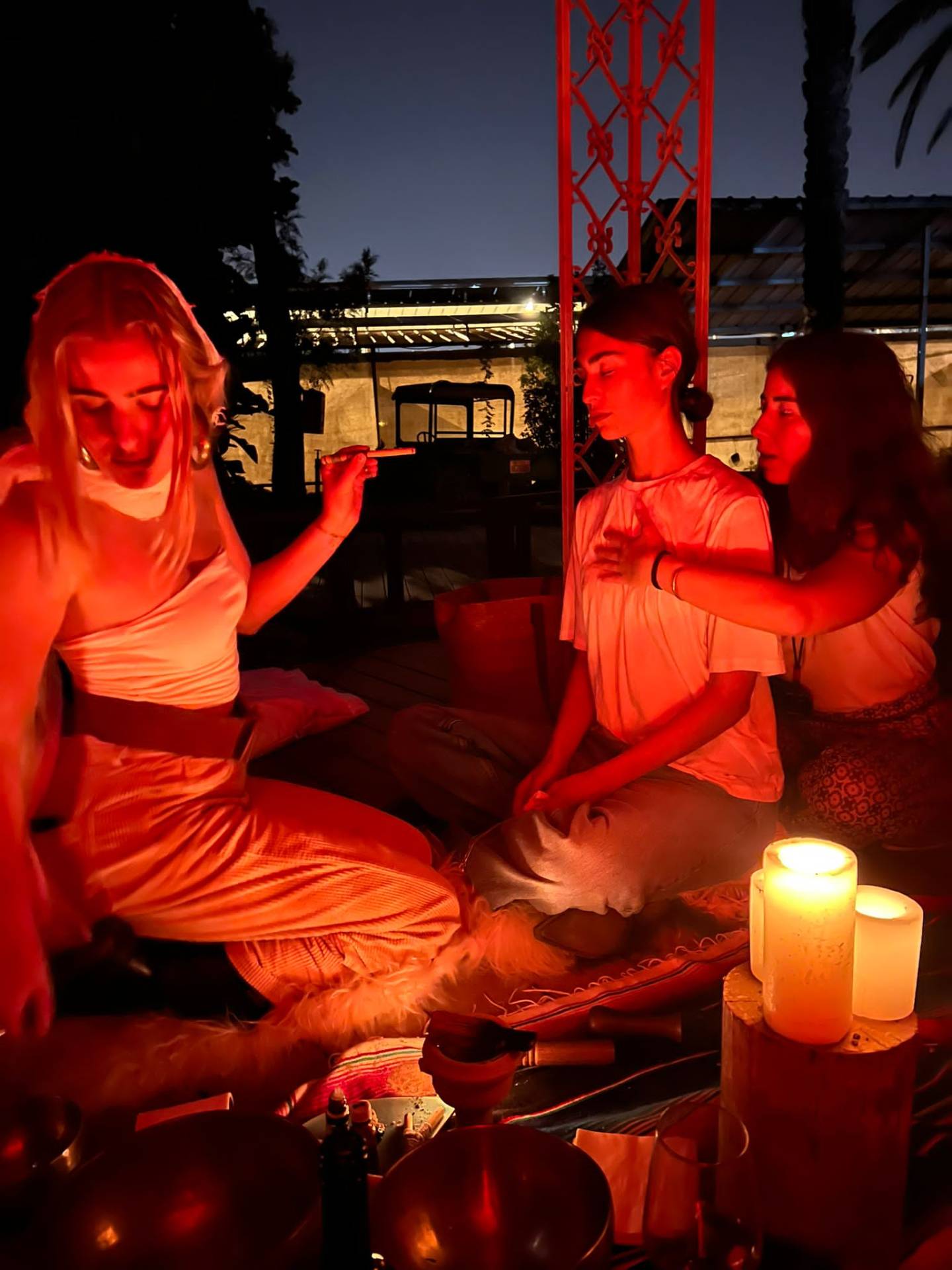 Three women in stillness under candlelight.