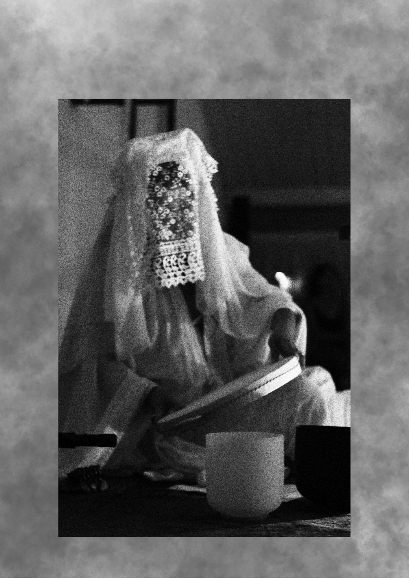 Veiled figure seated with crystal singing bowls in grainy black and white.